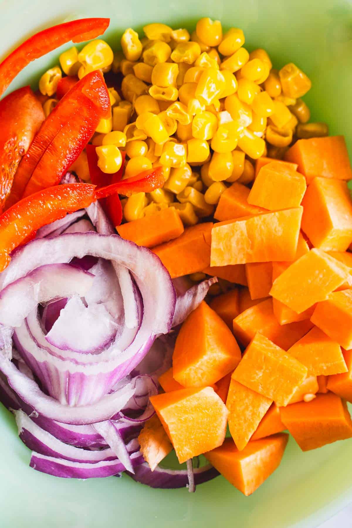 Cut fajita bowl vegetables in a green bowl with fajita seasoning.