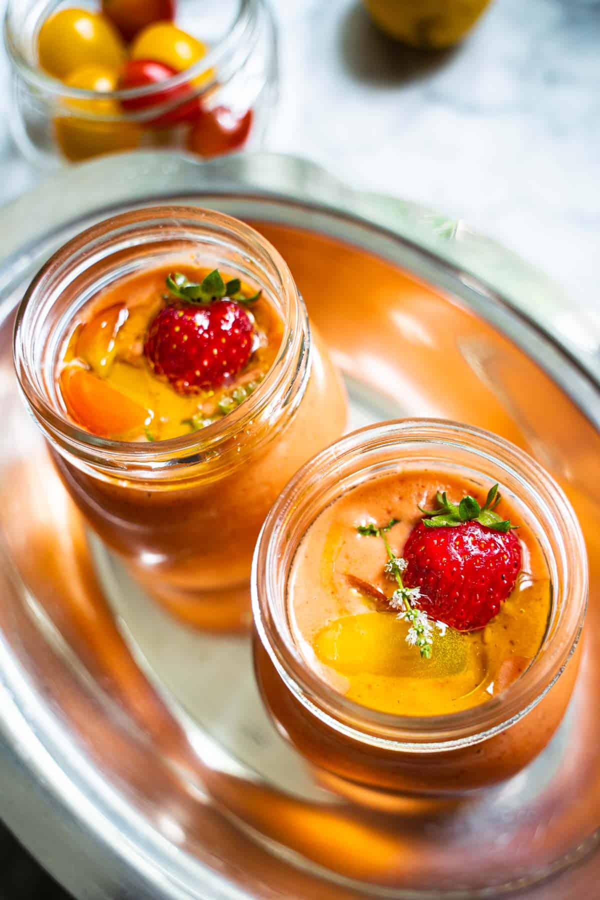 Easy Strawberry and Heirloom Gazpacho in individual sized mason jars on a silver platter