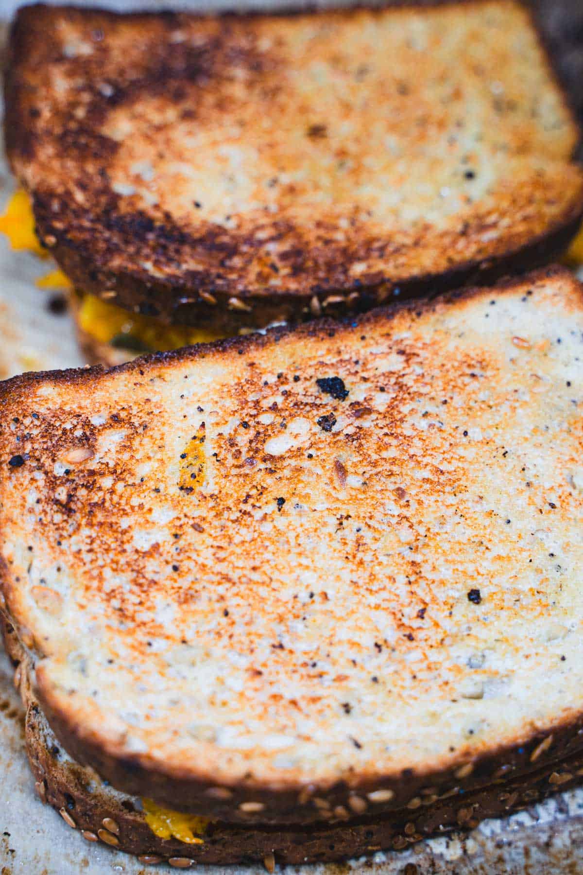 Two toasted adult grilled cheese with apple and butternut squash sandwiches on a baking sheet.