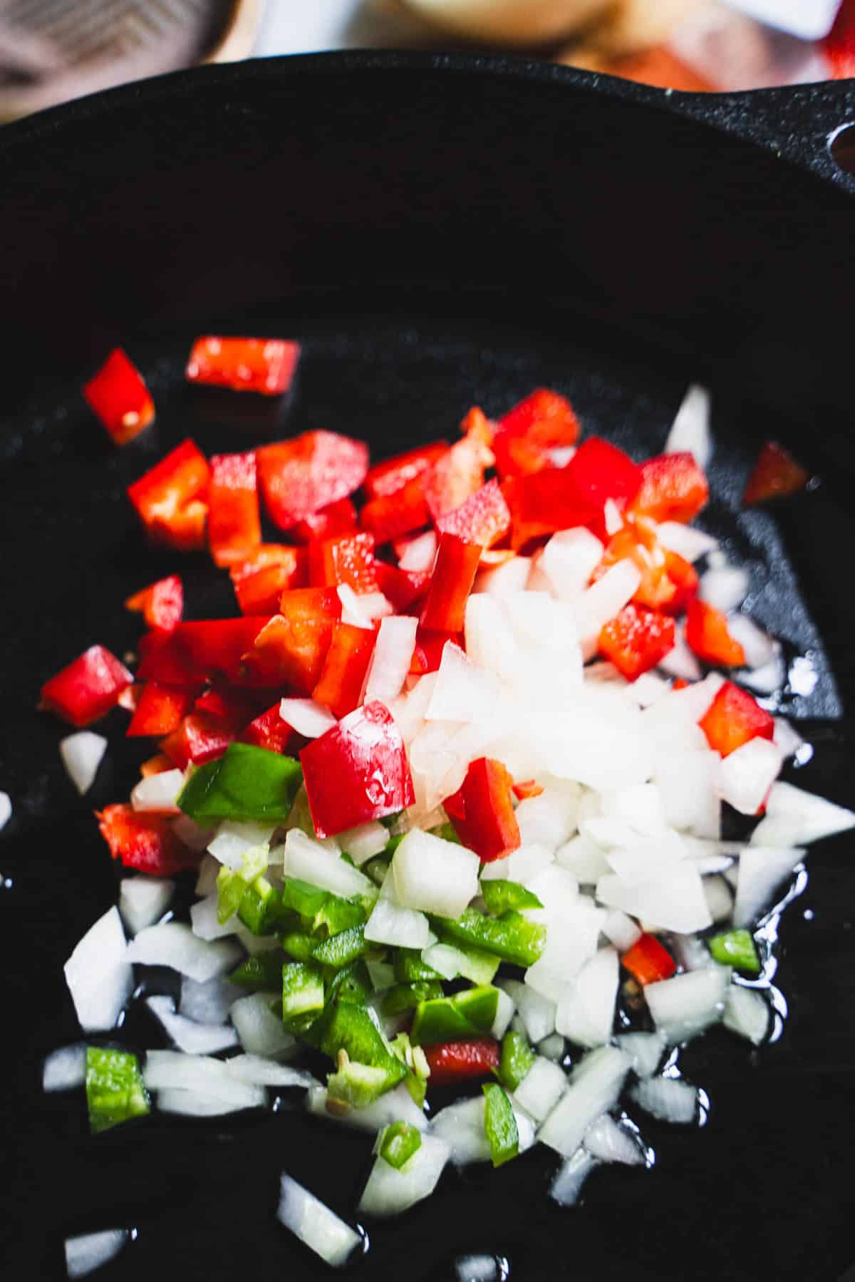 Chicken taco salad aromatics (peppers and onion) in a cast iron skillet.