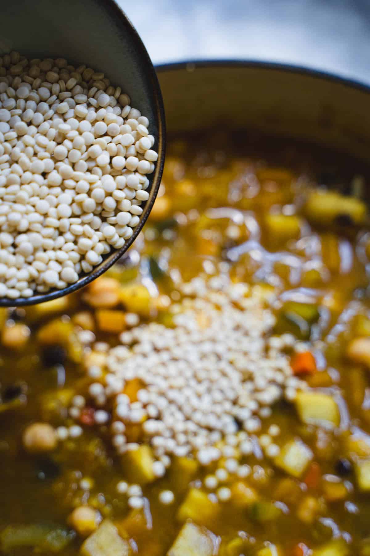 Couscous being added to the vegetarian butternut squash and chickpea tagine.