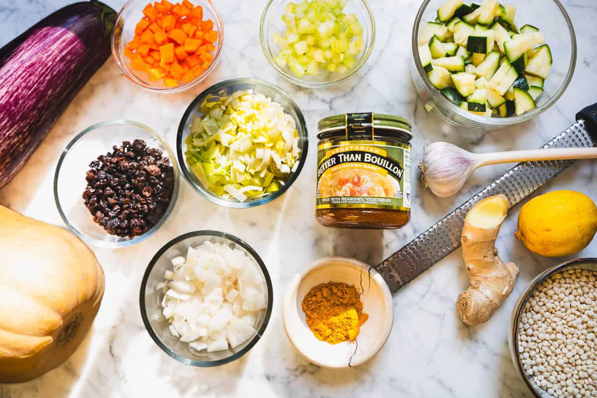 African cuisine ingredients to make a tagine recipe in glass bowls on a marble counter.