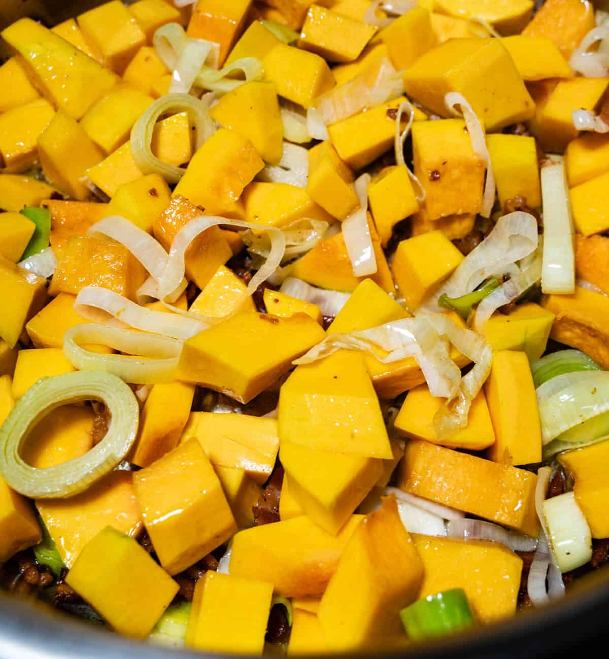 Squash, leeks and bacon in soup pot for apple butternut squash soup