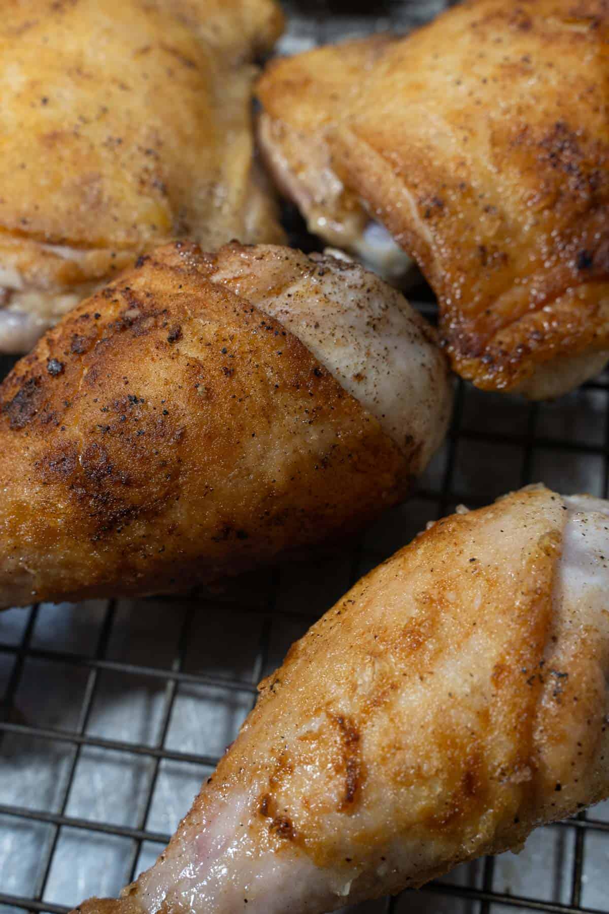 Seared chicken for Chicken Normandy resting on a wire rack.