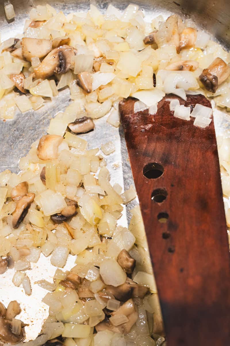 Onion and mushrooms in a saute pan to build flavor to the wild rice soup.