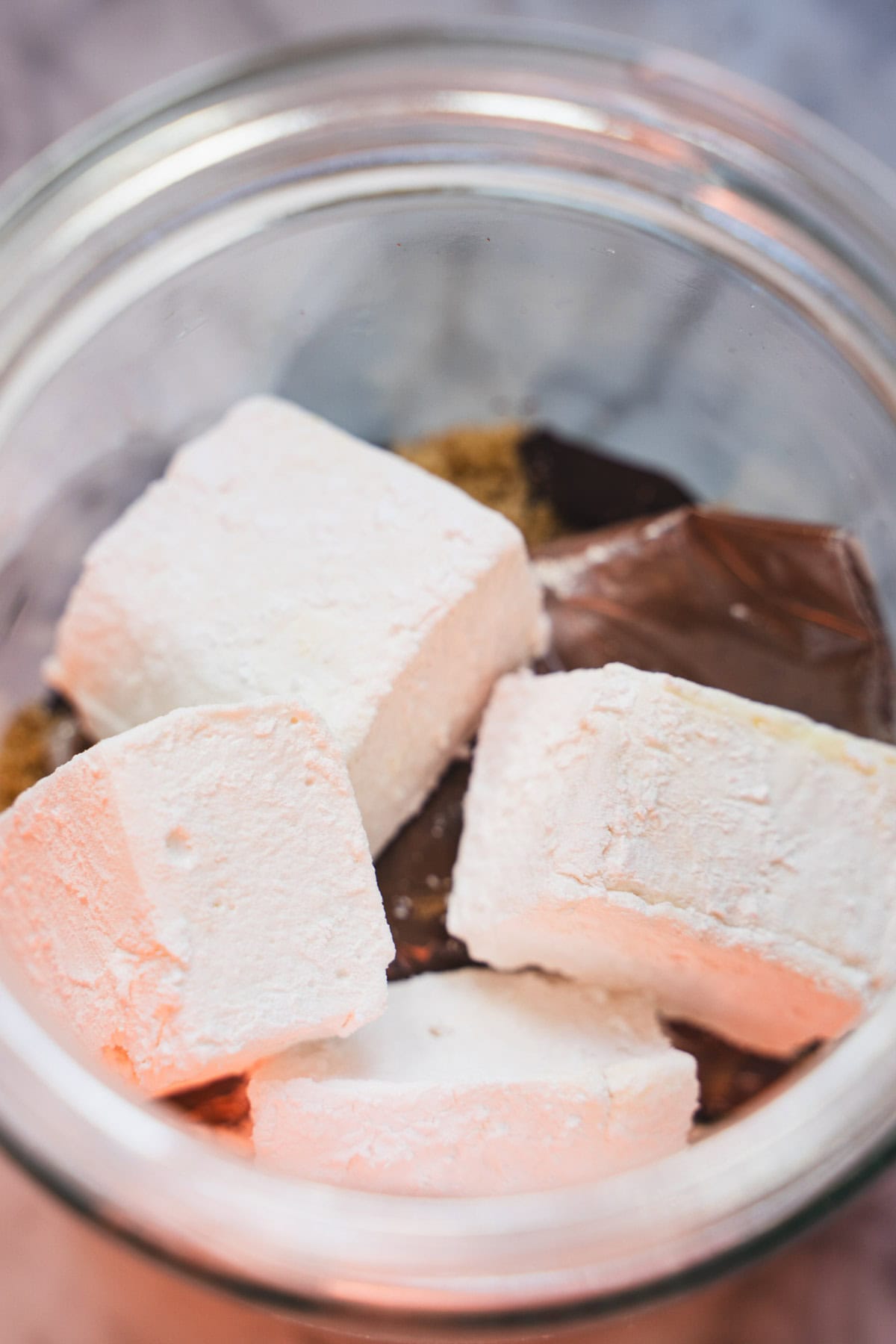 Marshmallows on top of dark hot chocolate hot cocoa mix.