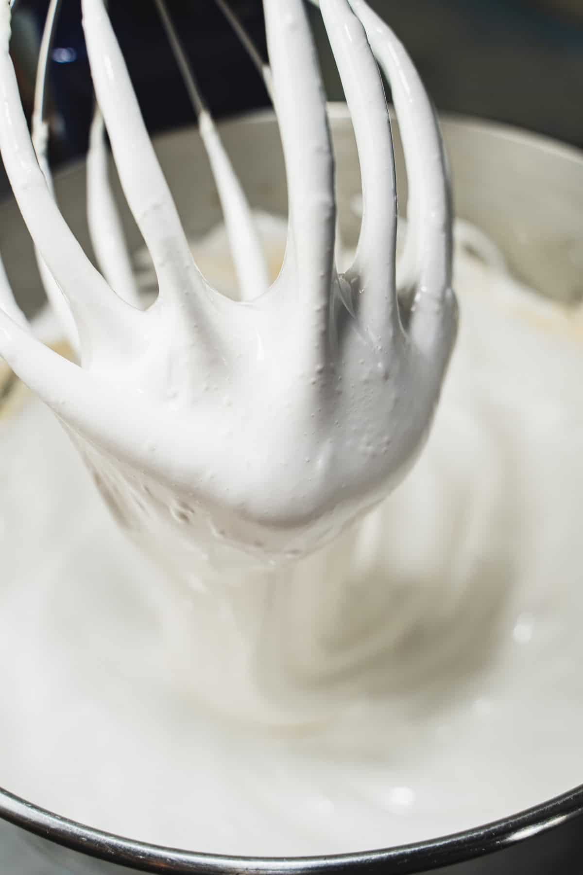Homemade marshmallows batter on whisk and in a stand mixer bowl.