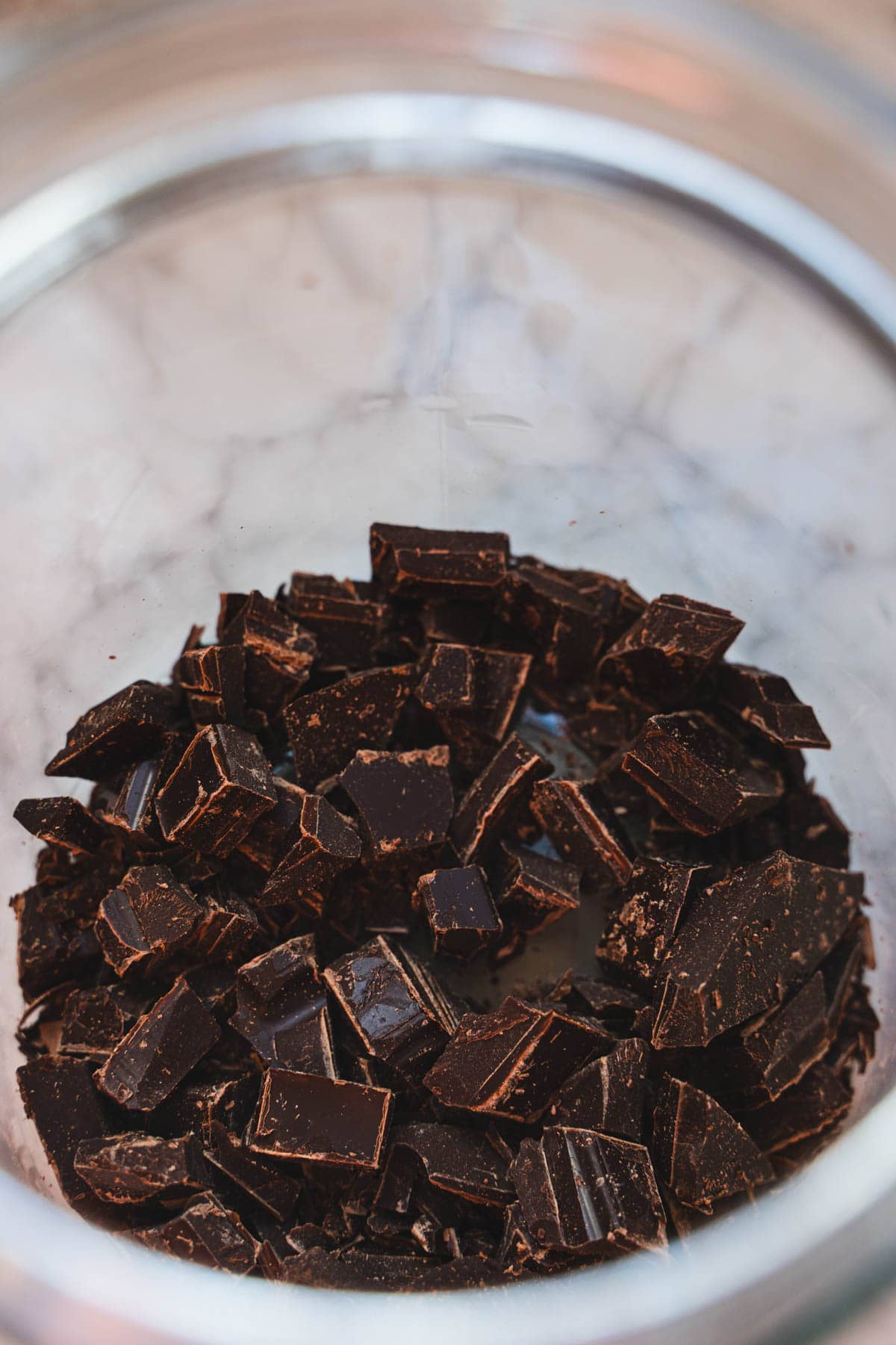 Layer of chopped dark chocolate in bottom of glass jar for dark hot chocolate mix.