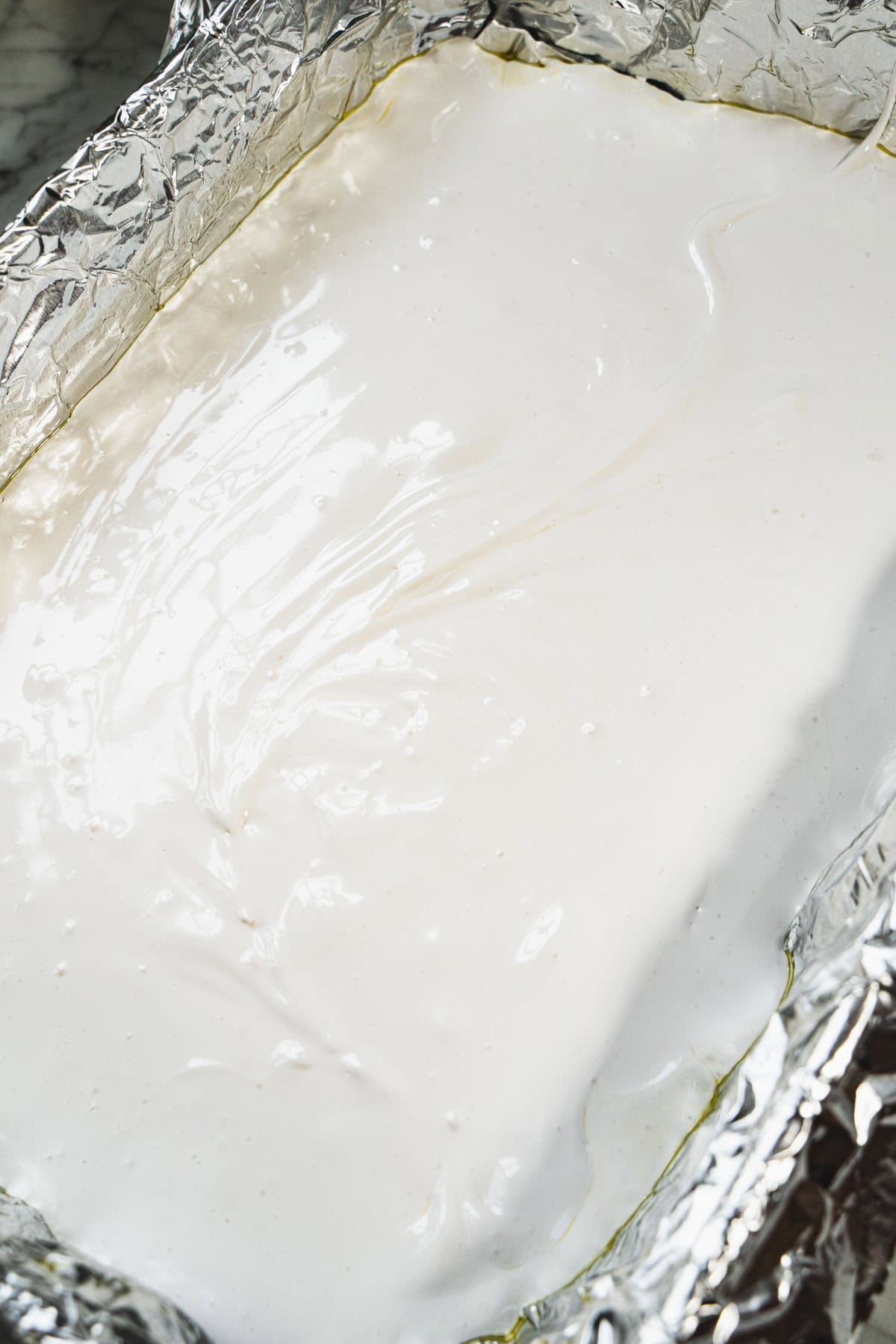 Homemade marshmallow white fluff in a foil lined pan.