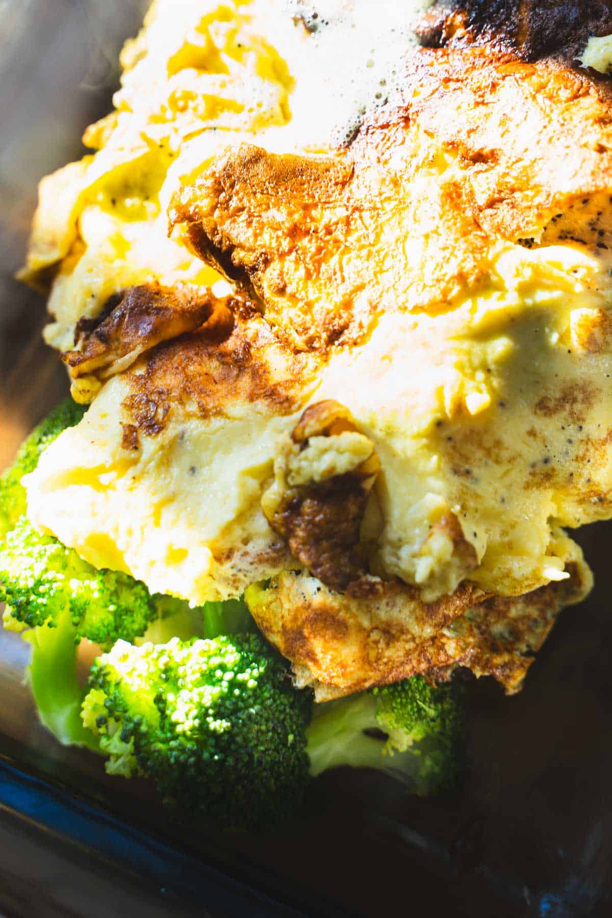 Cooked eggs placed on top of broccoli in a loaf pan for cottage cheese egg casserole.