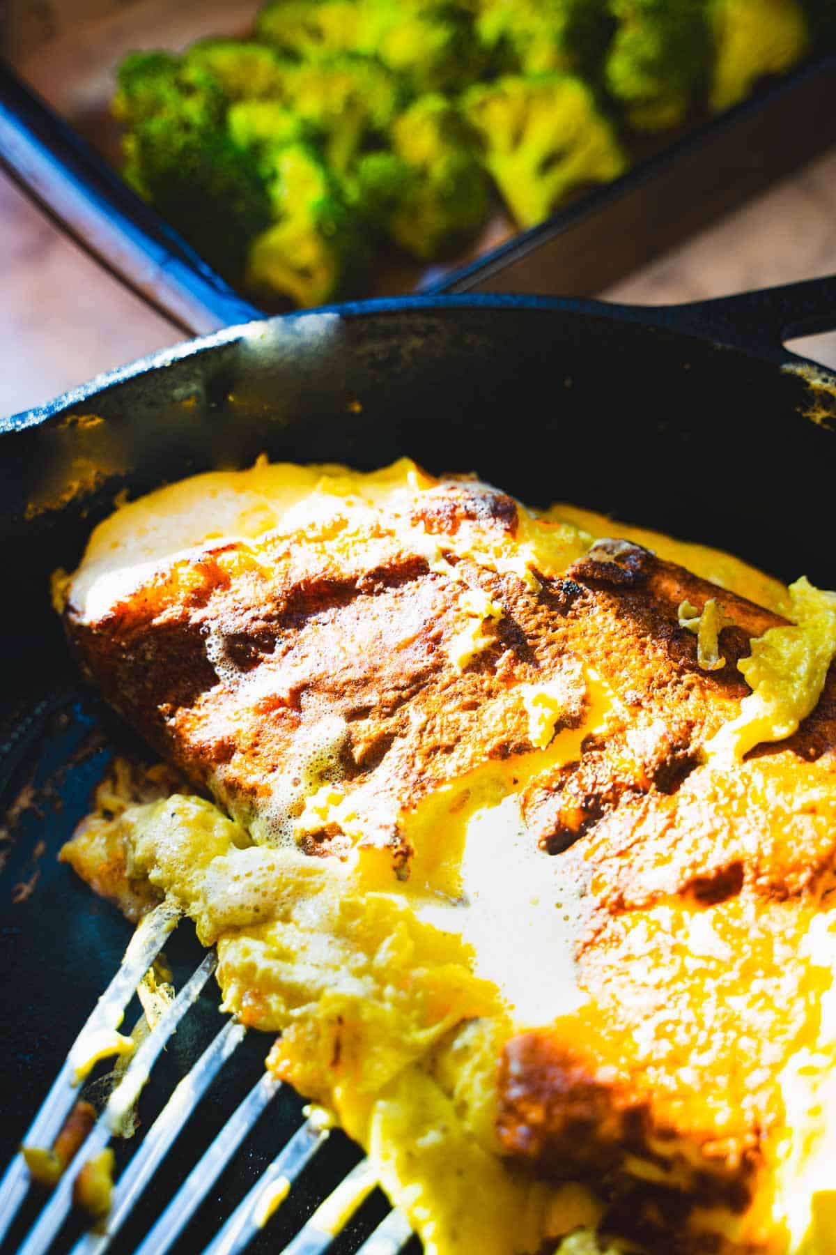 Lifting eggs and turning in cast iron pan with a fish spatula for the cottage cheese egg bake.