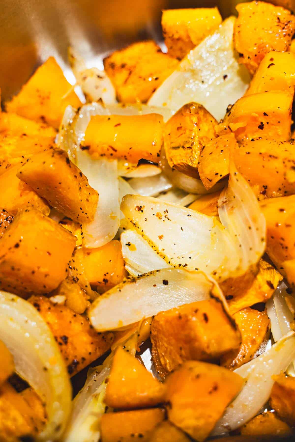 Roasted sweetpotatoes and shallots on baking sheet for peanut butter and sweet potato coconut milk soup.
