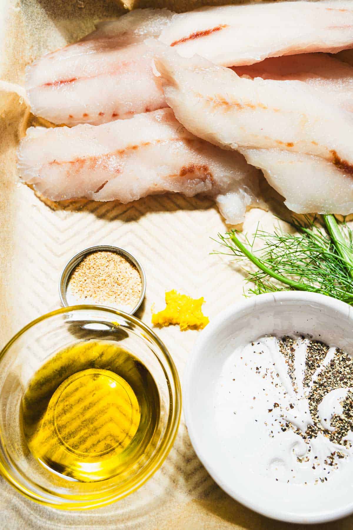 Ingredients on parchment paper to season the yellowtail fish.