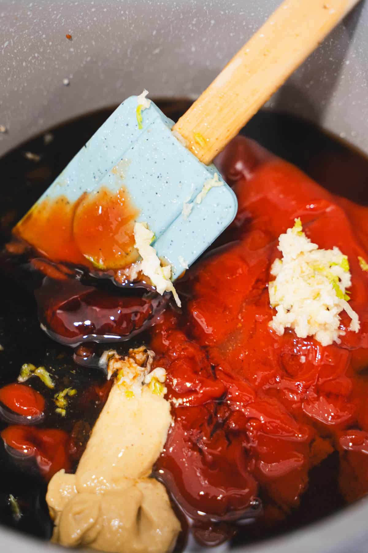 BBQ sauce ingredients in a sauce pan with a spatula for sticky ribs.