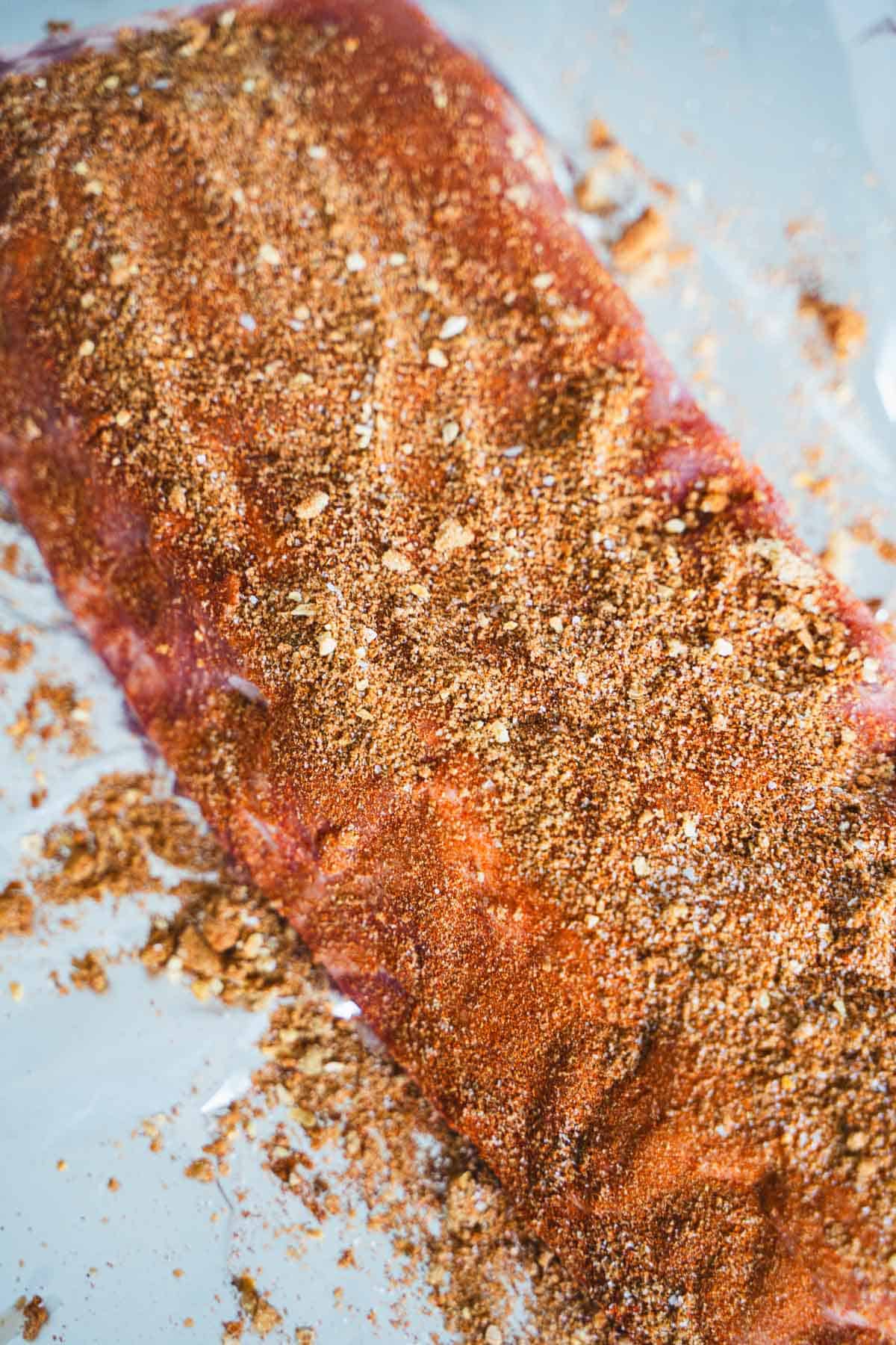Dry rub pressed into ribs on aluminum foil.