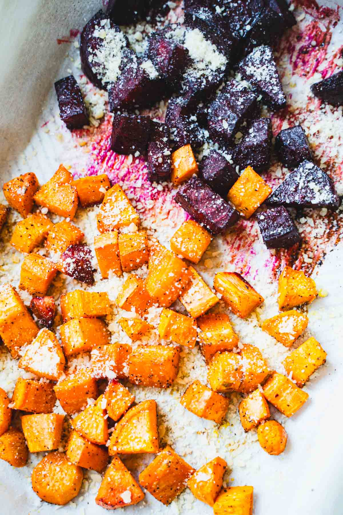 Roasted beets and sweet potatoes on baking sheet sprinkled with parmesan cheese for Breakfast Hash.