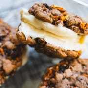 3 carrot cake sandwich cookies piled on top of each other in a glass container.