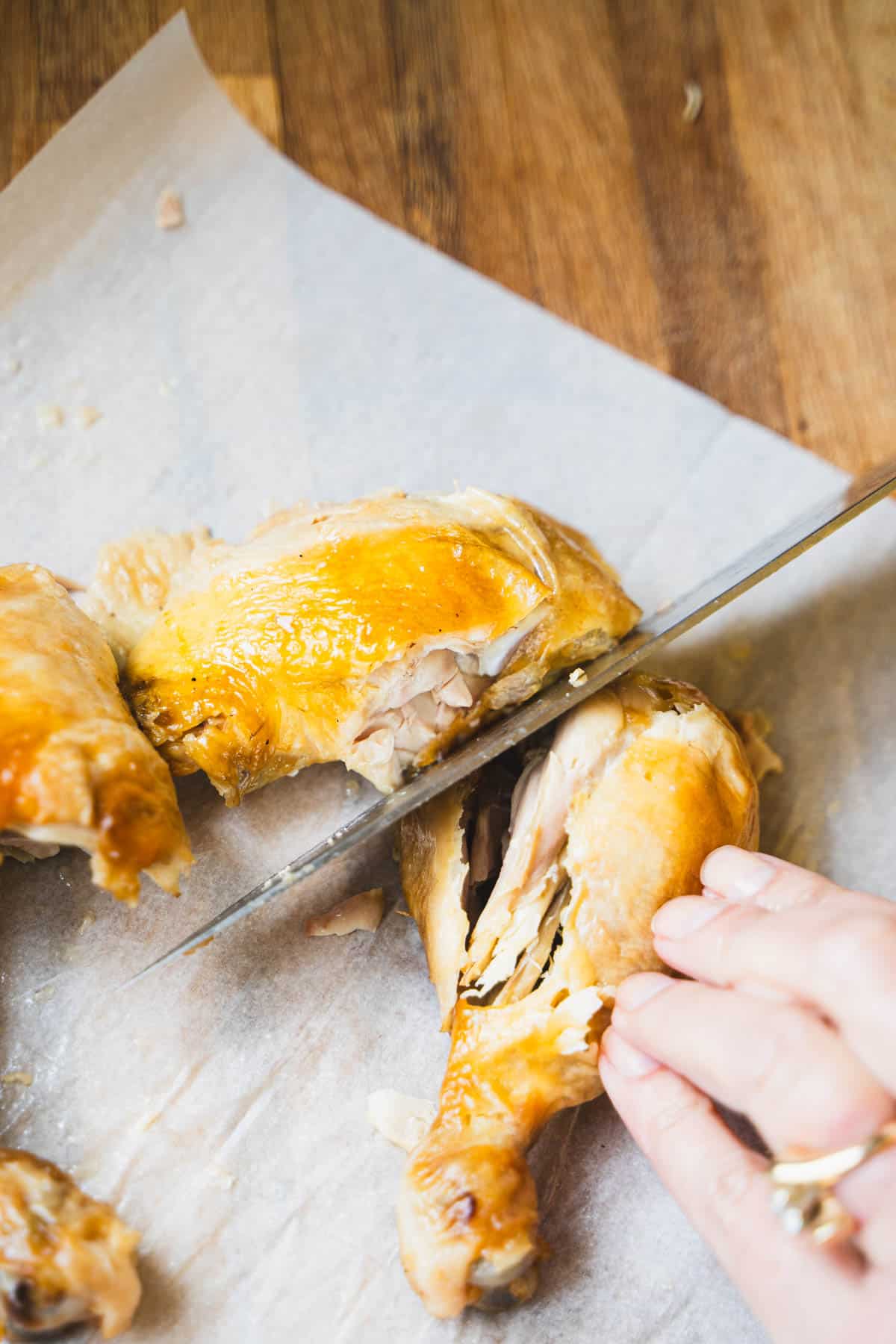 knife cutting through joint to separate drumstick and thigh.