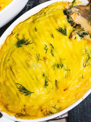 Baked seafood pot pie in an individual white ramekin.