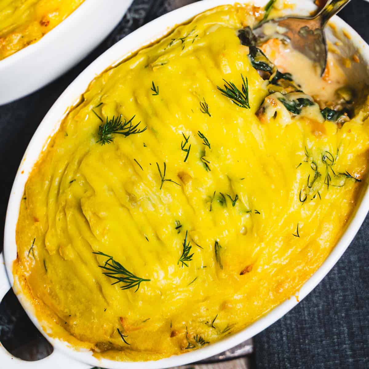 Baked seafood pot pie in an individual white ramekin.