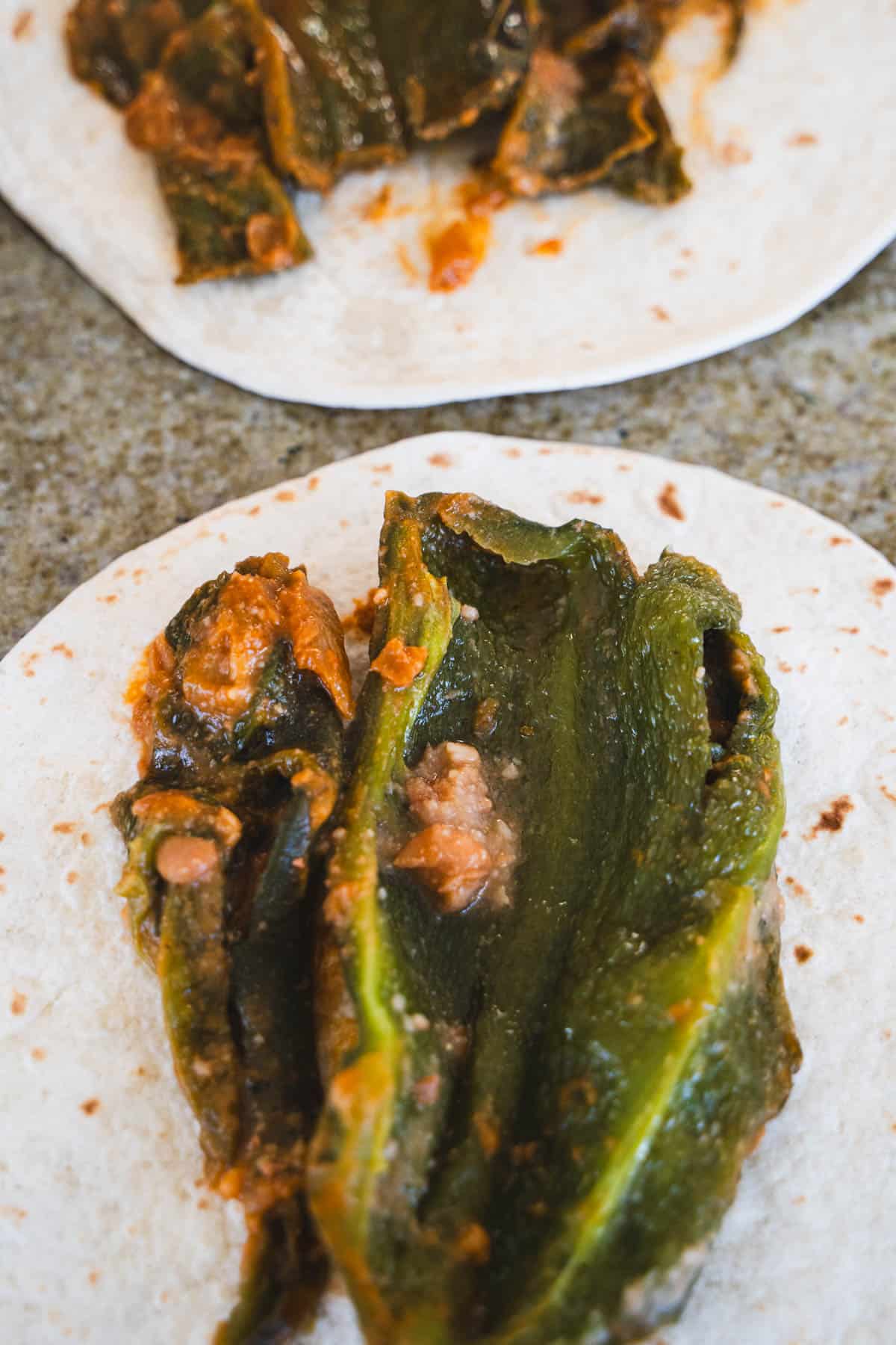 Chile relleno pepper on tortilla for the first layer to make baked chile relleno burriot