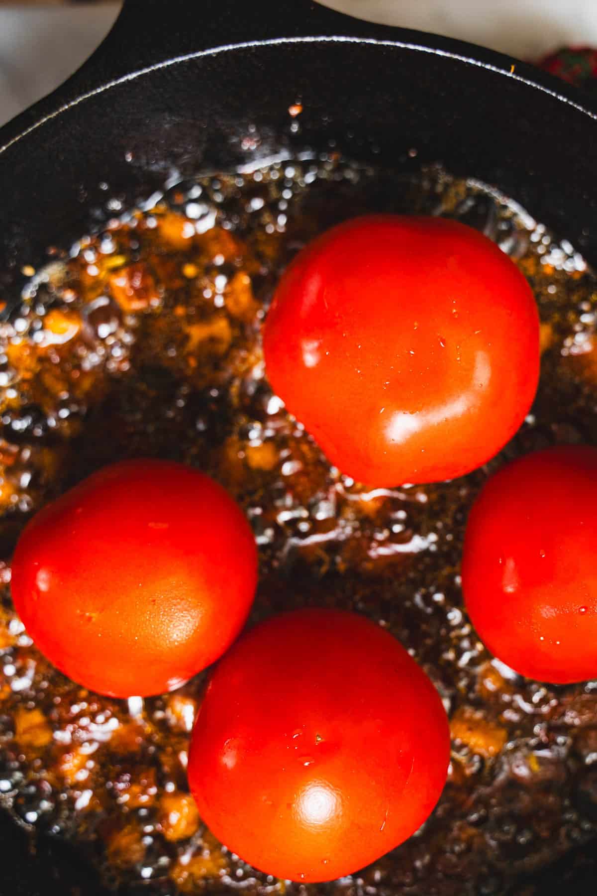 Pancetta, tomatoes and olive oil in a cast iron skillet.