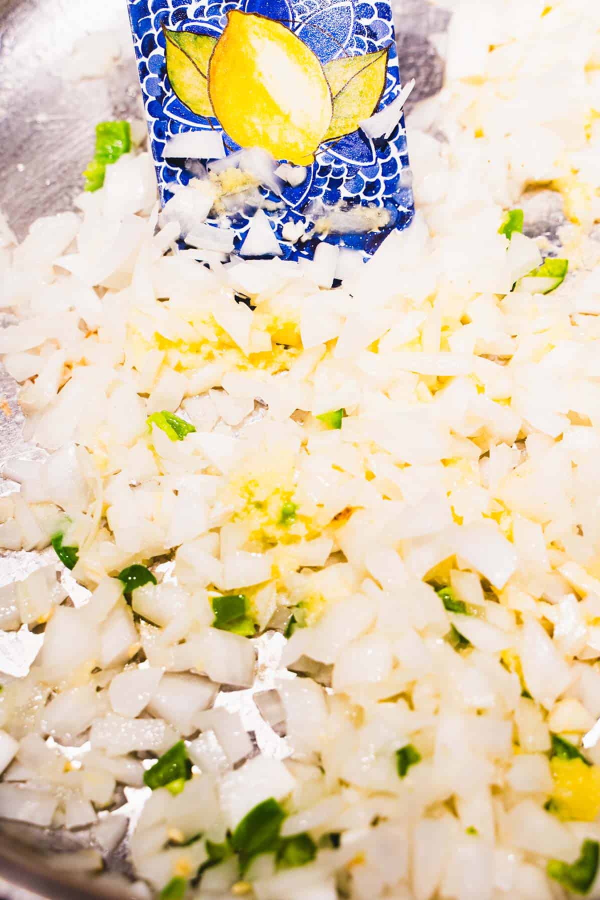 Onion, garlic, ginger and chile in a saute pan to build the butter chicken sauce.