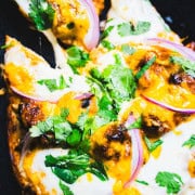 Naan and Butter Chicken Pizza slice being pulled away from the whole pizza.