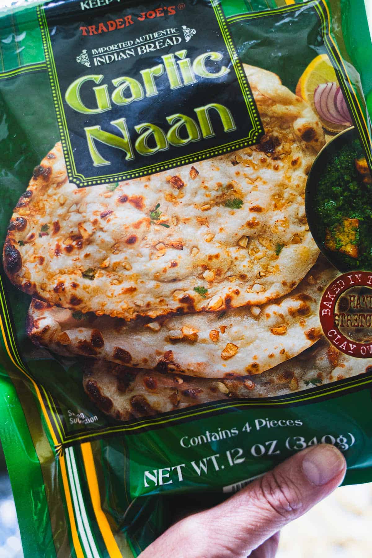 Hand holding a package of trader joe's Garlic Naan.