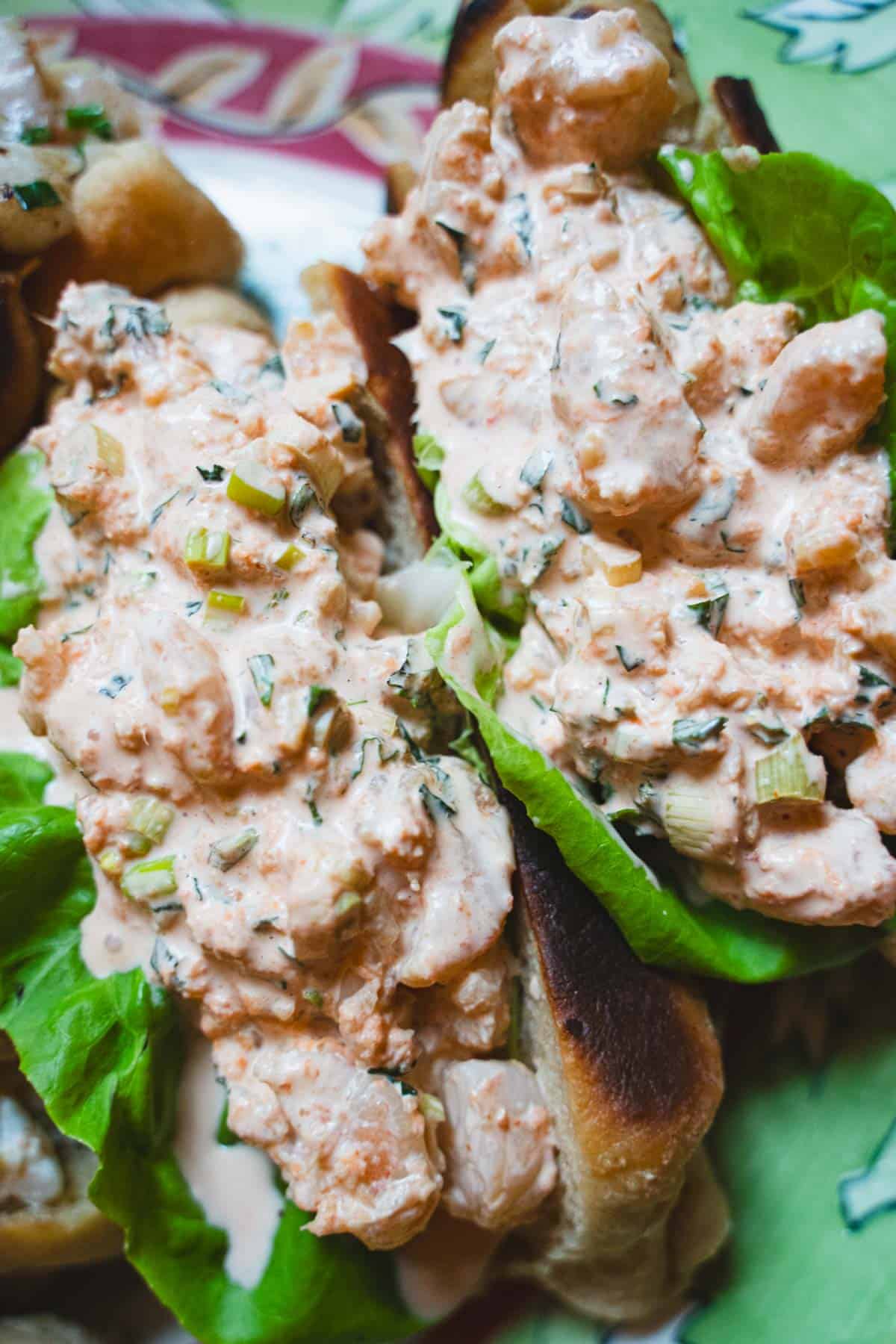 Two asian style shrimp rolls on a green platter.