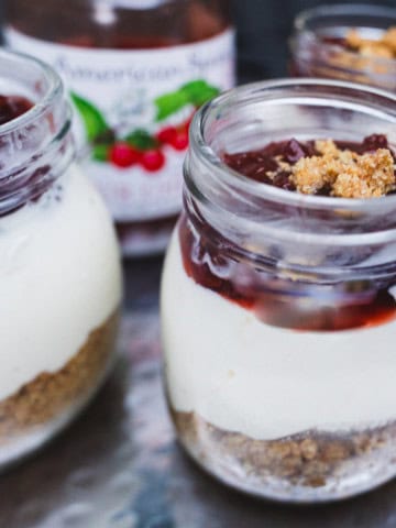 Cherry topping added to the no bake cheesecake in a mason jar.