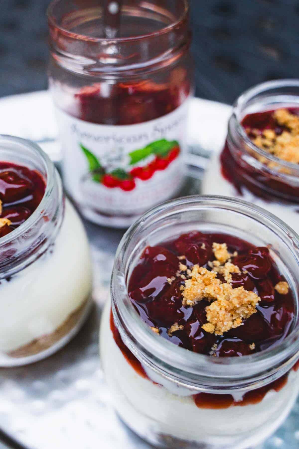 Cherry topping added to the no bake cheesecake in a mason jar.