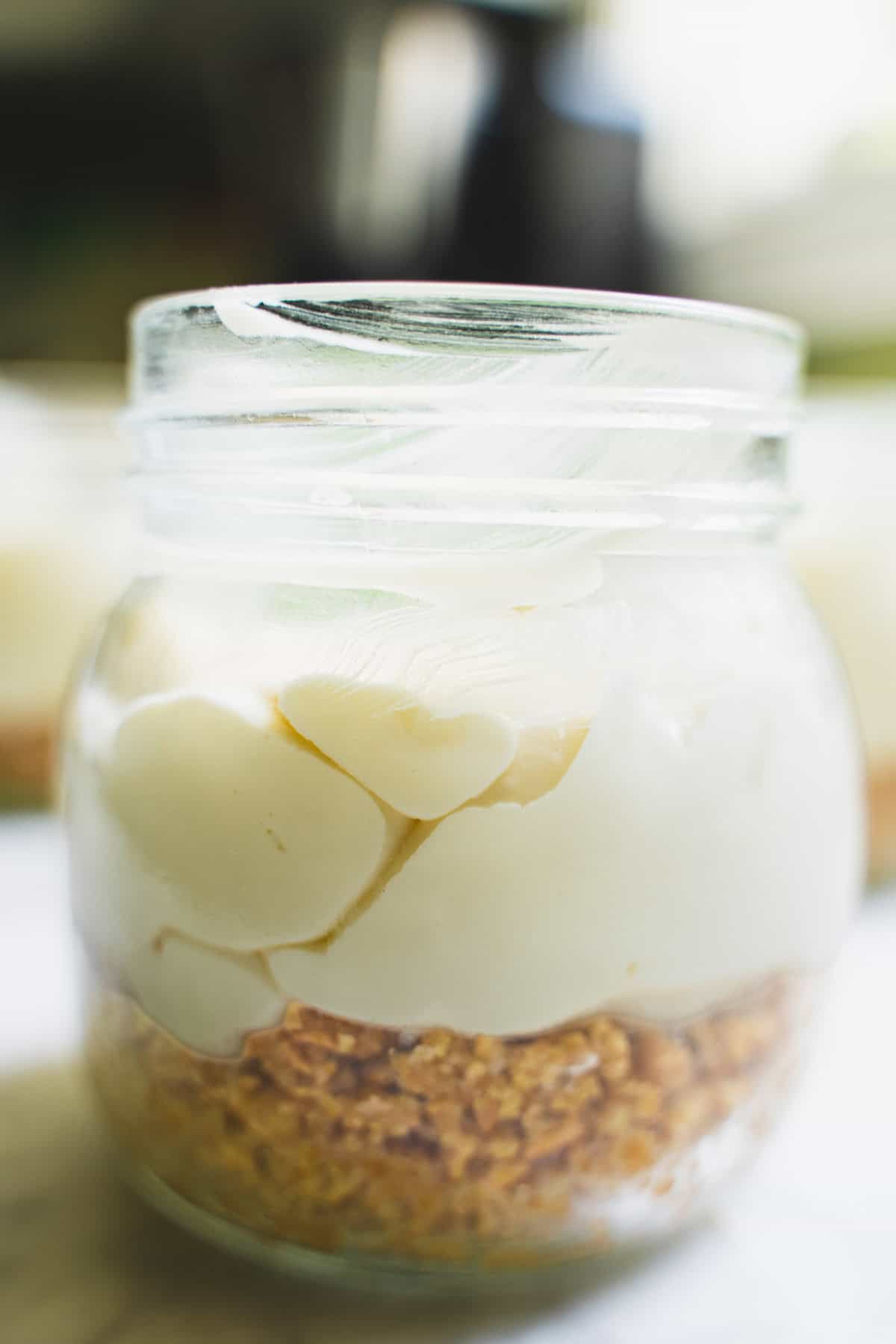 Filling that has been spooned into mason jar on top of a layer of graham crackers.