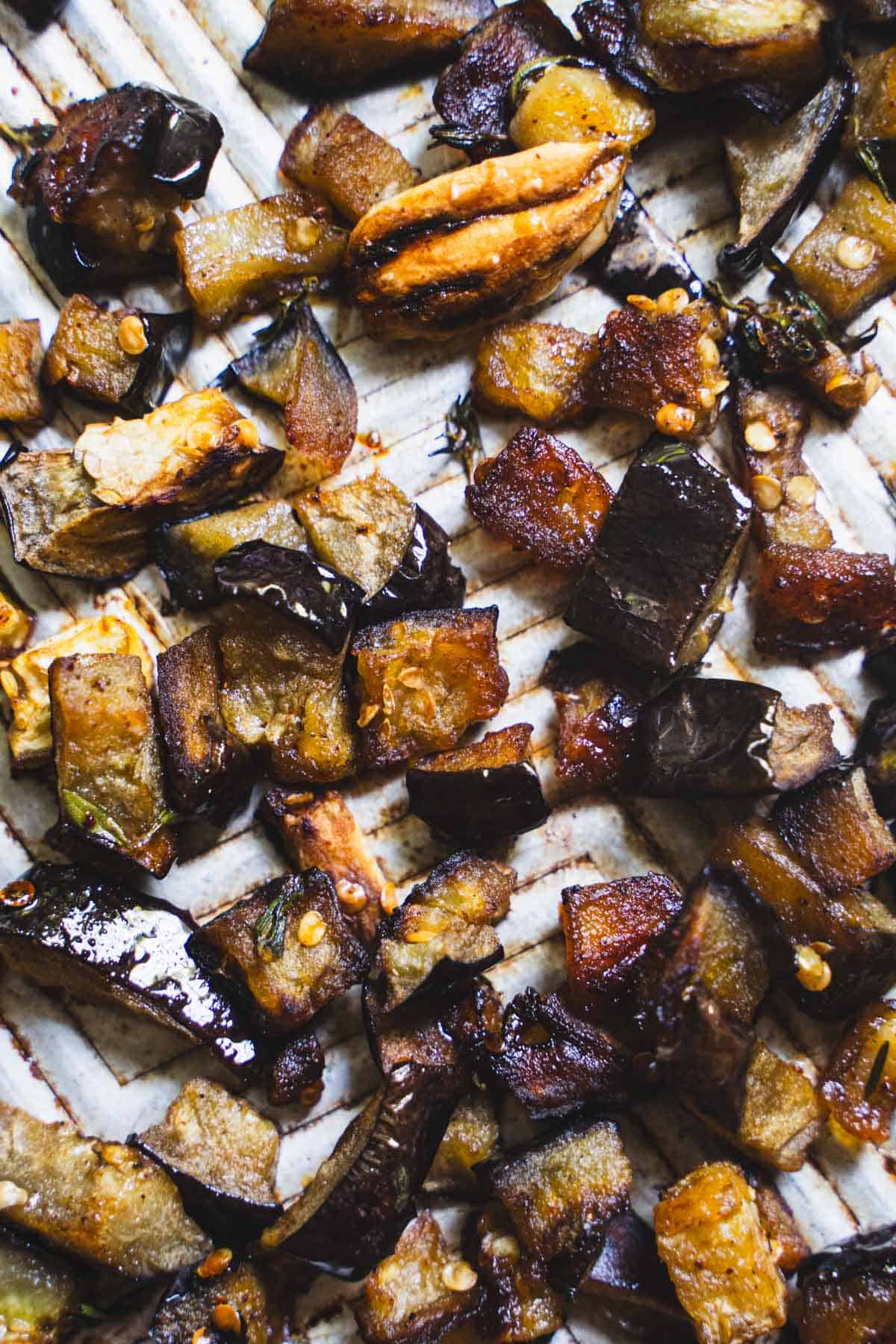 Roasted eggplant cubes on a baking sheet for orzo salad.