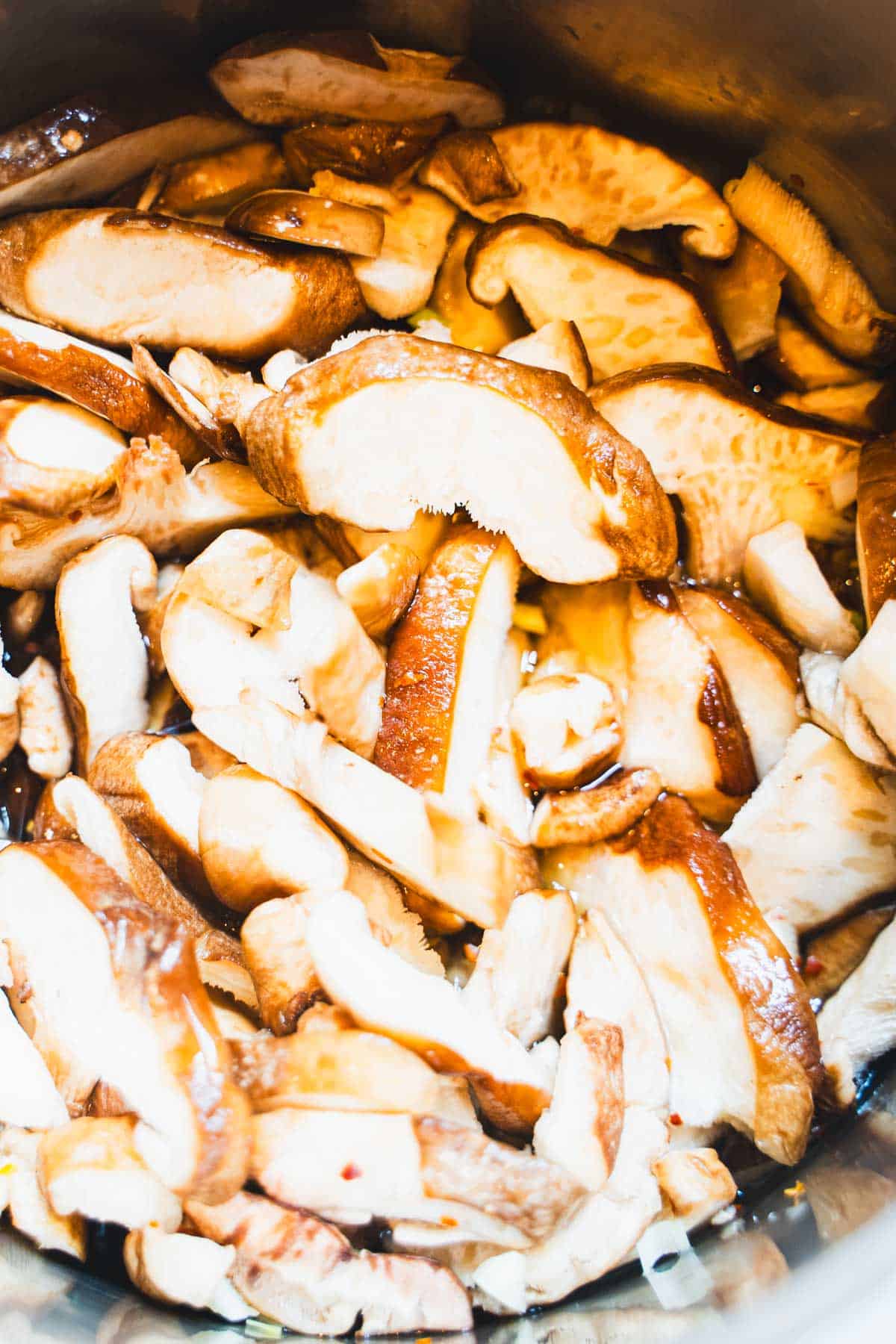 Sliced mushrooms in a saucepan with pickling brine.