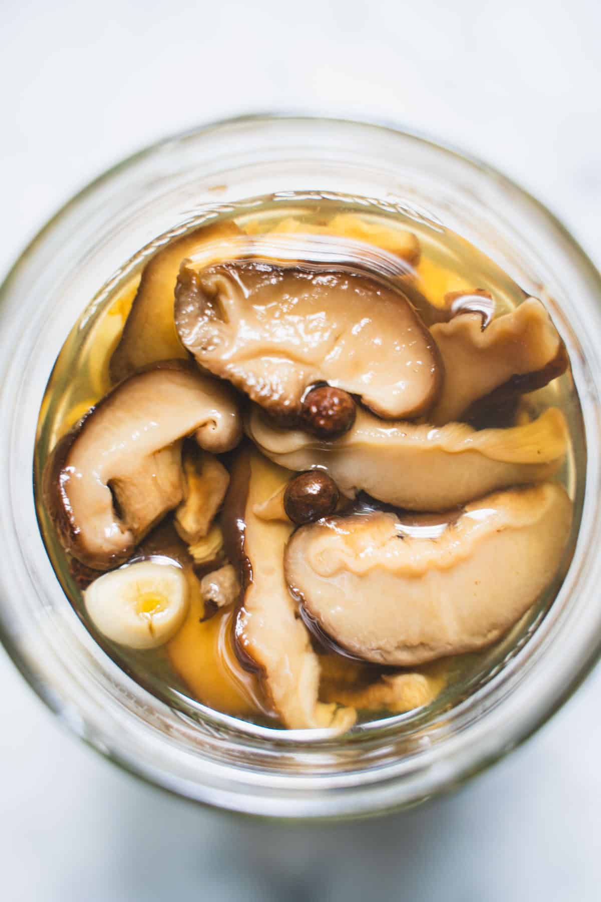 Pickled Mushrooms in a clear glass mason jar.