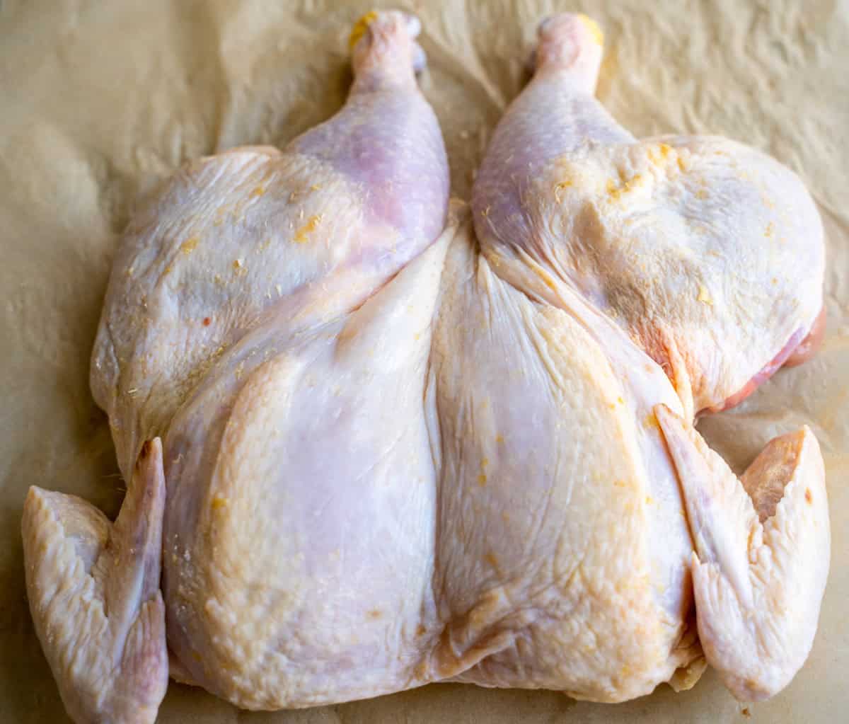 Backbone removed and breastside up of spatchcock chicken.