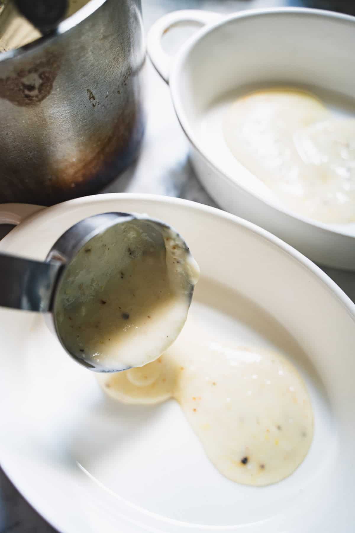 bechamel spooned into bottom of individual white ramekins.