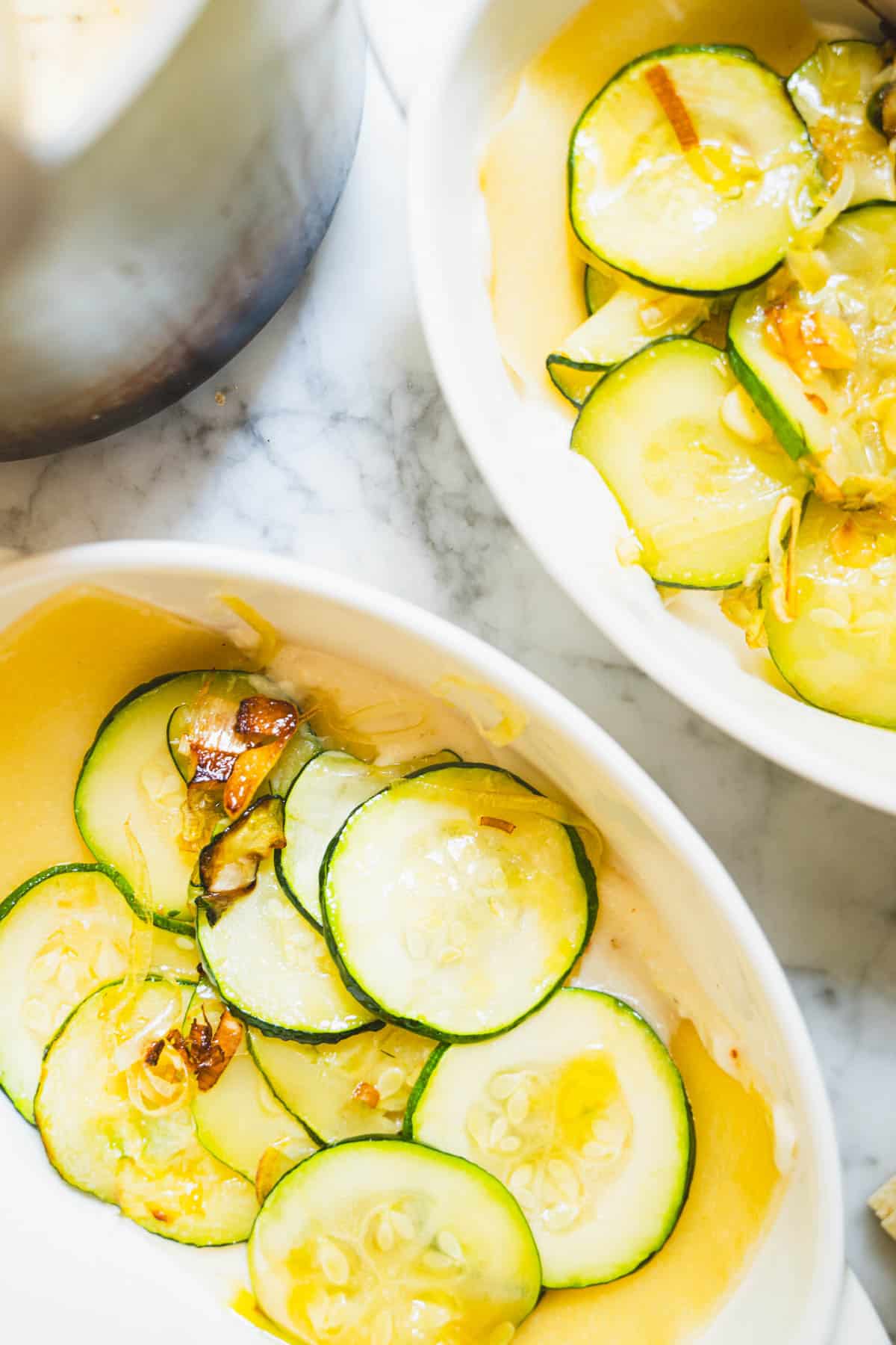 Zucchini and leek mixture layered on top of lasagna noodle in white ramekin.