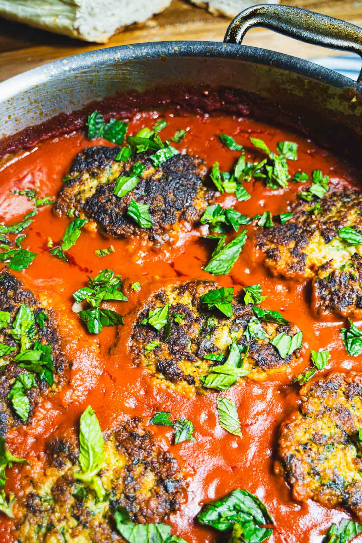Cod cakes in tomato sauce sprinkled with chopped mint.
