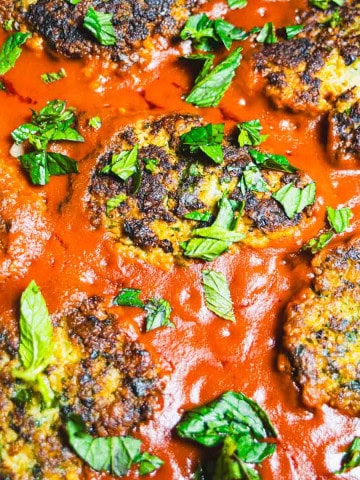 Cod cakes in tomato sauce sprinkled with chopped mint.