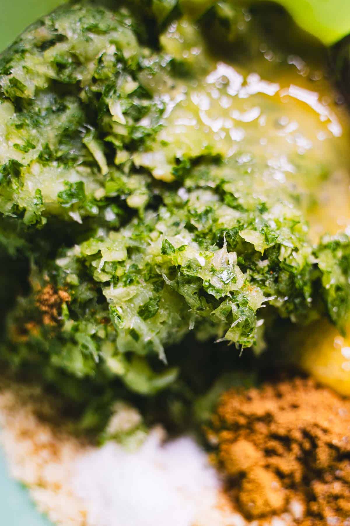 Cod cake mixture in a green mixing bowl with spices and beaten egg.