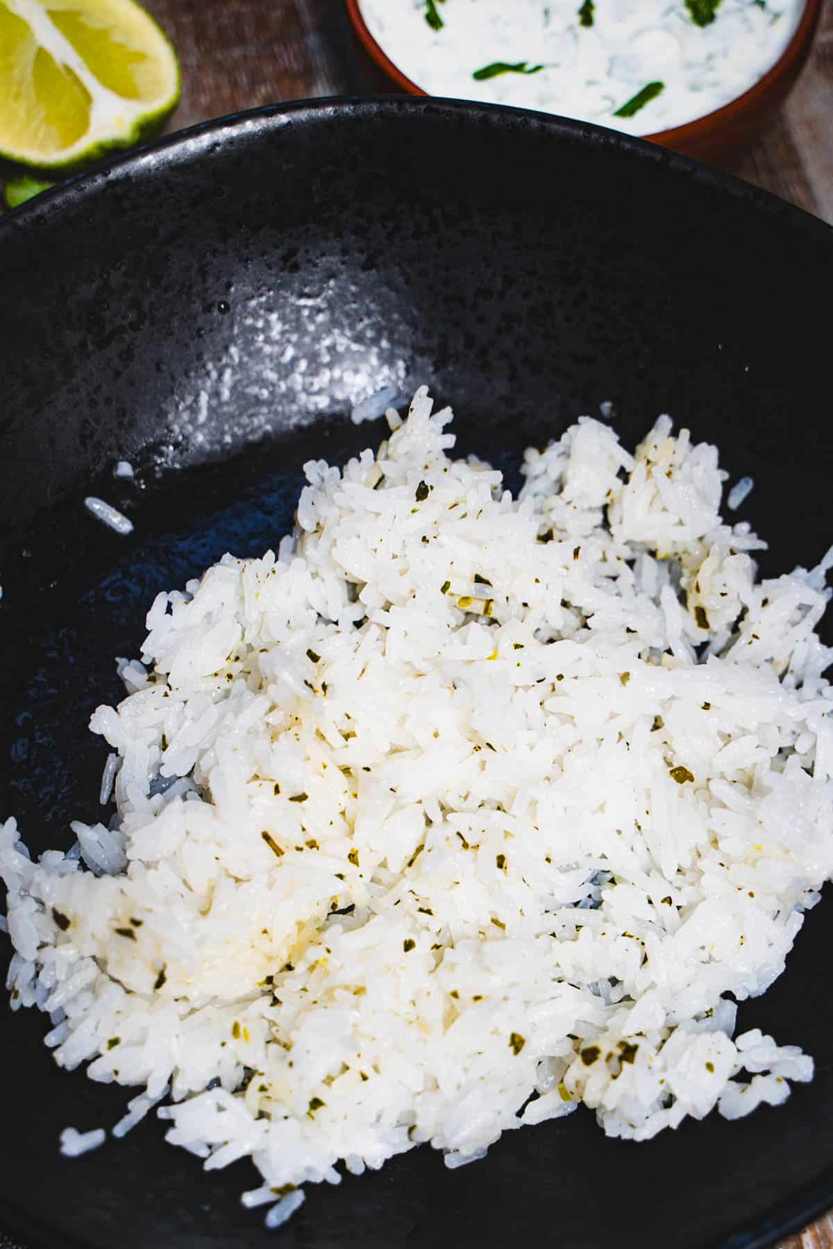Cilantro lime rice in black bowl for salsa verde chicken rice bowls.