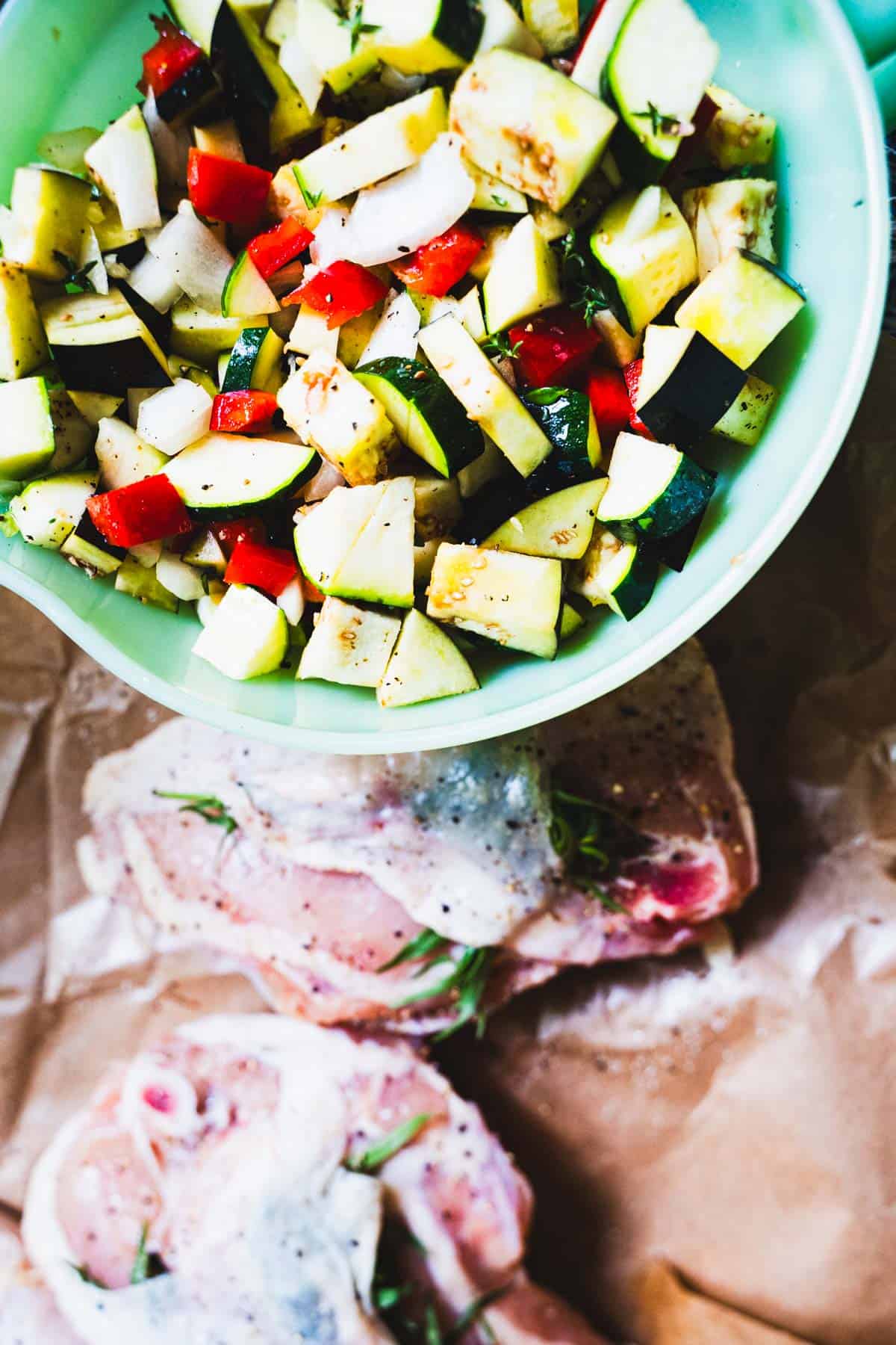 Vegetables for ratatouille chopped in ½-inch cubes in a green bowl.